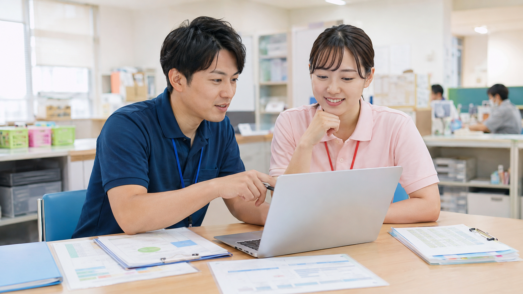 介護施設で職員が記録業務や情報共有を行っている様子